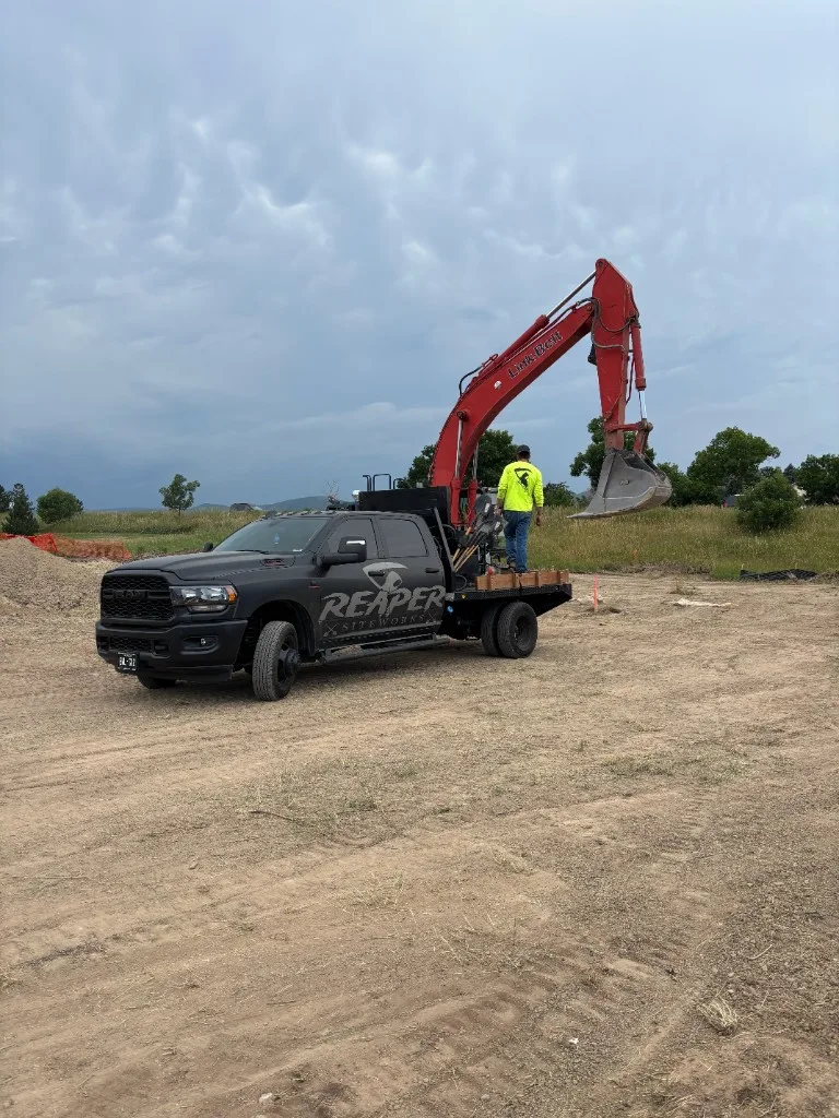 Reaper Siteworks branded truck with Link-Belt excavator on a job site